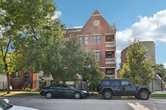 Front view of a multi-story brick building with balconies.