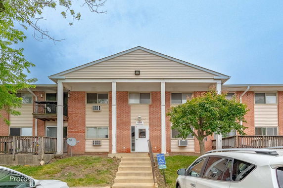 Front view of a multi-story building with brick facade and columns.