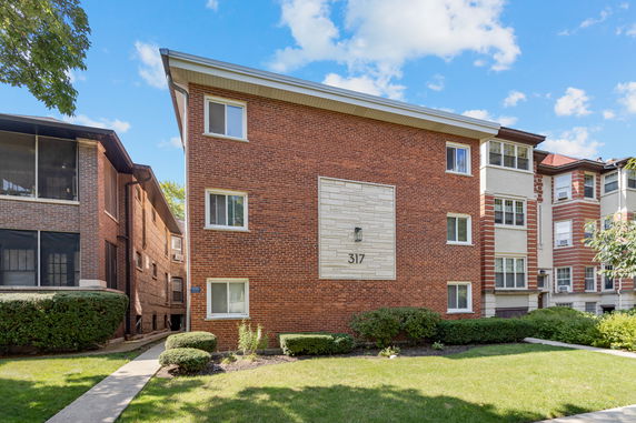 Front view of a multi-story brick building with number 317.