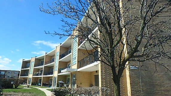 Front view of a multi-story apartment building with balconies.
