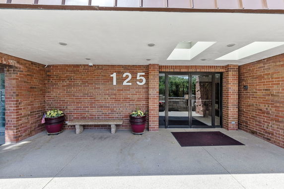 Entrance of a brick building with glass double doors and number 125.