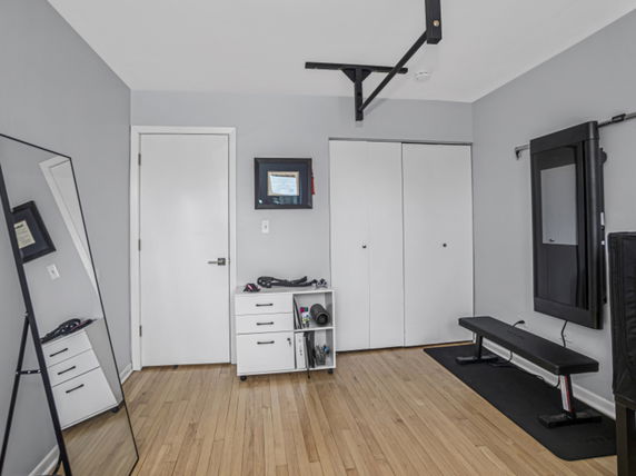Room with exercise equipment and a bench.