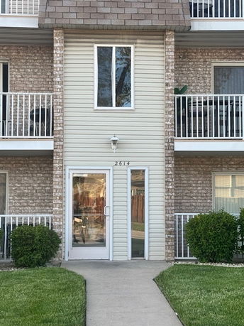 Front view of a multi-story residential building with balconies and a main entrance.