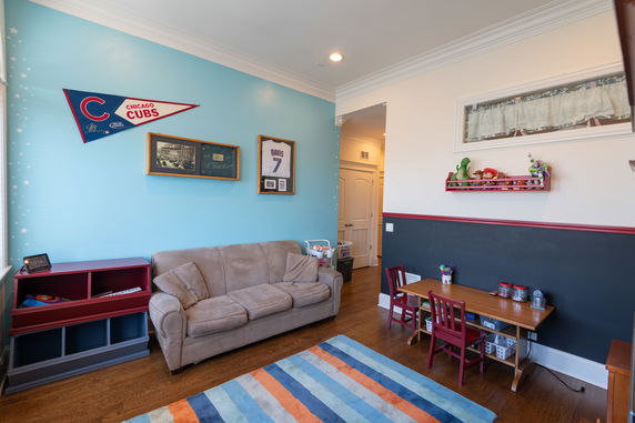 Playroom with a sofa, small table, and chairs, decorated with a sports theme.