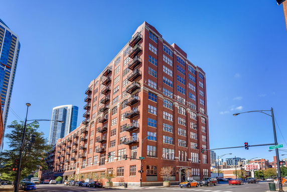 Front view of a multi-story brick building with balconies.