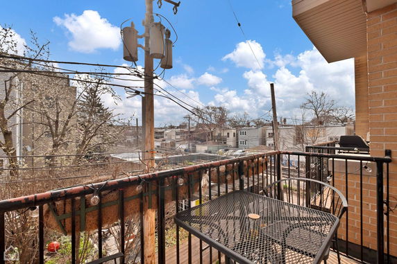 Panoramic view from a balcony showing urban residential buildings and power lines.