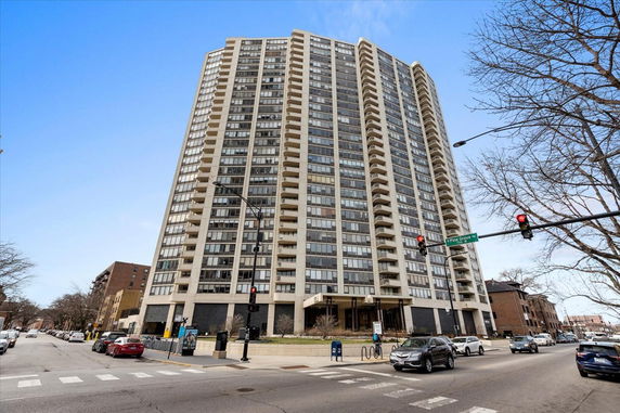 Front view of a high-rise residential building with multiple balconies.