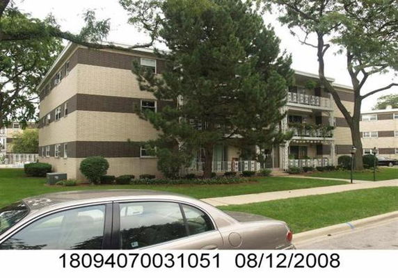 Front view of a multi-story apartment building with balconies.