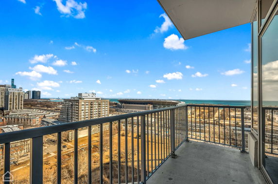 Balcony view overlooking cityscape with buildings and an expansive skyline.