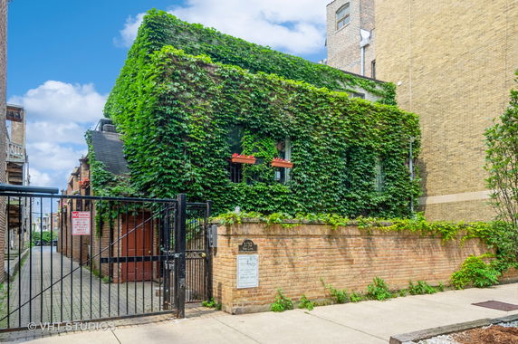 Front view of a building covered in green ivy.