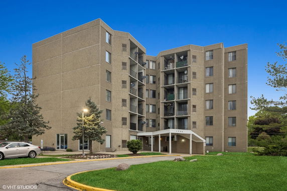Front view of a multi-story apartment building with balconies.