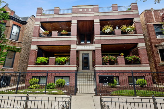 Front view of a multi-story brick building with balconies.