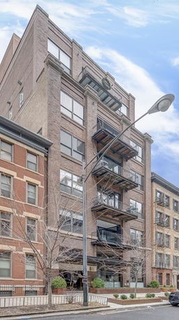Front view of a multi-story residential building with brick facade and balconies.