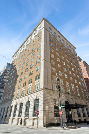 Front view of a multi-story brick building with numerous windows.