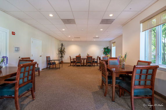 Indoor recreational area with tables and chairs arranged in a spacious room.