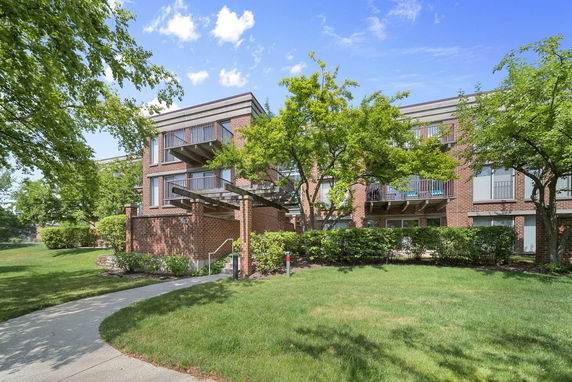 Front view of a brick apartment building with balconies.