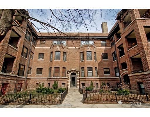 Front view of a multi-story brick apartment building with an entrance arch.