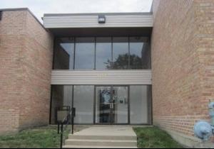 Front view of a building with large glass windows and brick exterior walls.
