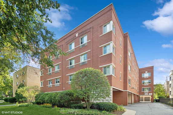 Front view of a multi-story brick building with numerous windows.