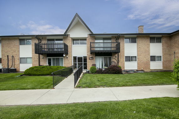 Front view of a two-story apartment building with balconies and a central entrance.