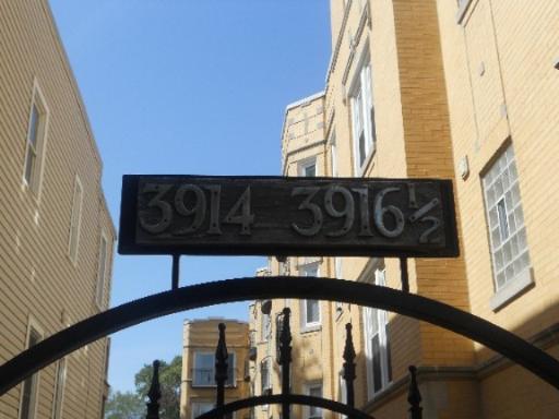 Front view of a multi-story building with an address sign reading '3914-3916½'.