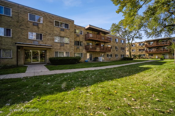 Front view of a three-story apartment building with balconies.