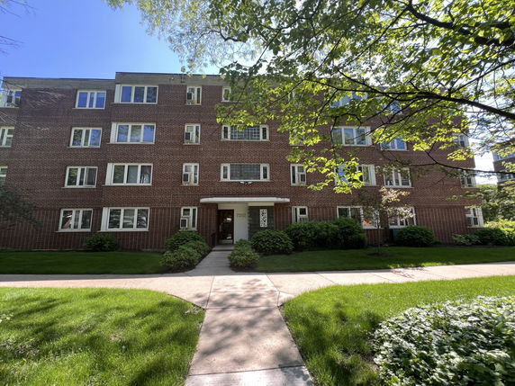 Front view of a four-story brick apartment building.
