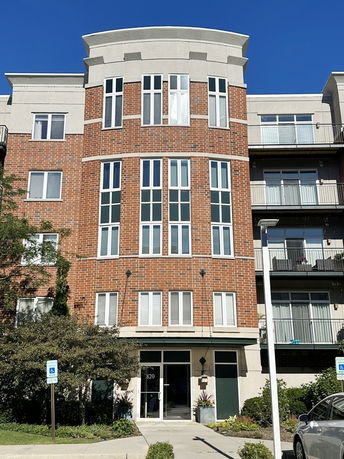 Front view of a multi-story brick building with large windows and a central entrance.