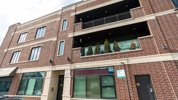 Front view of a multi-story brick building with balconies.