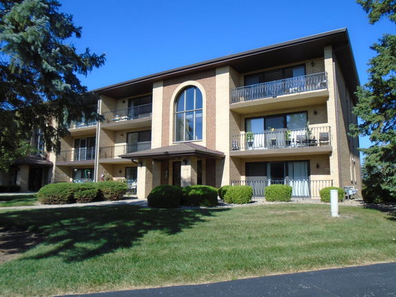 Front view of a three-story apartment building with balconies.