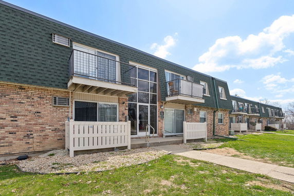 Front view of a two-story apartment building with balconies and brick exterior.