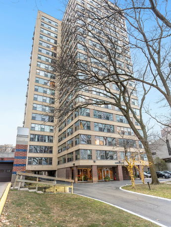 Front view of a multi-story residential building with large windows.