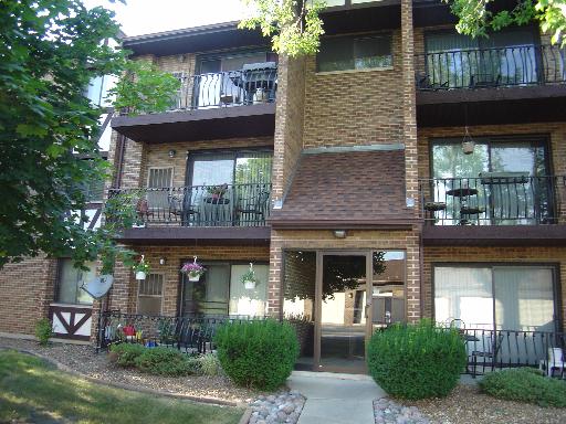 Front view of a multi-story apartment building with balconies.