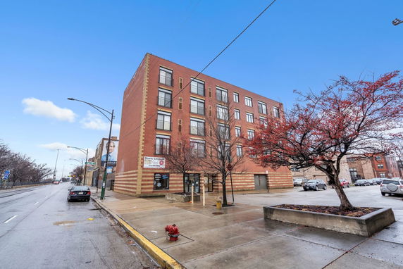 Front view of a multi-story brick building on a city street.