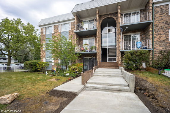 Front view of a multi-story apartment building with balconies.