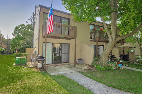 Front view of a two-story house with balconies and sliding doors.
