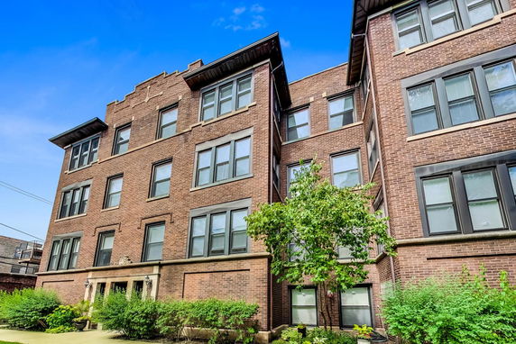 Front view of a four-story brick apartment building.