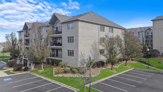Front view of a multi-story residential building with a gabled roof.