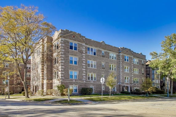 Front view of a brick apartment building with multiple windows.