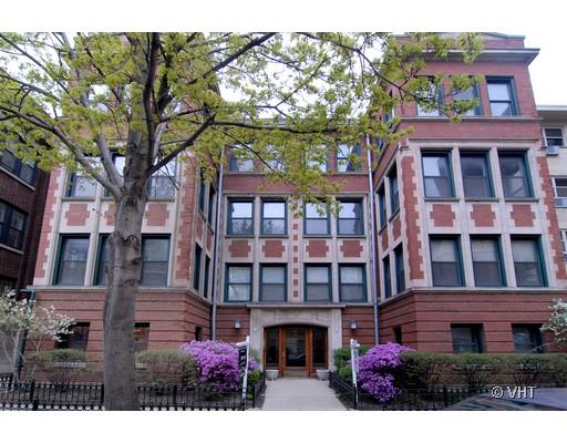 Front view of a multi-story brick apartment building with large windows.
