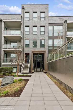 Front view of a modern multi-story apartment building with balconies.