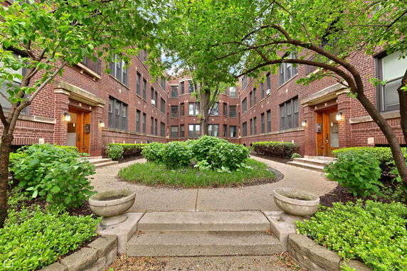 Front view of a brick apartment building with multiple entrances.