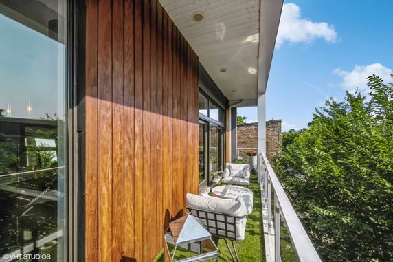 View from a modern balcony with wood paneling and outdoor seating.