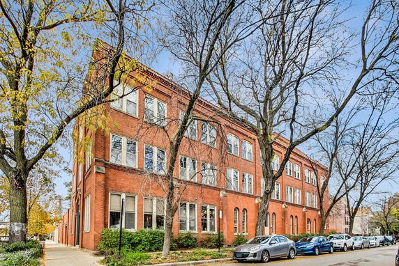 Front view of a three-story brick building with multiple windows.
