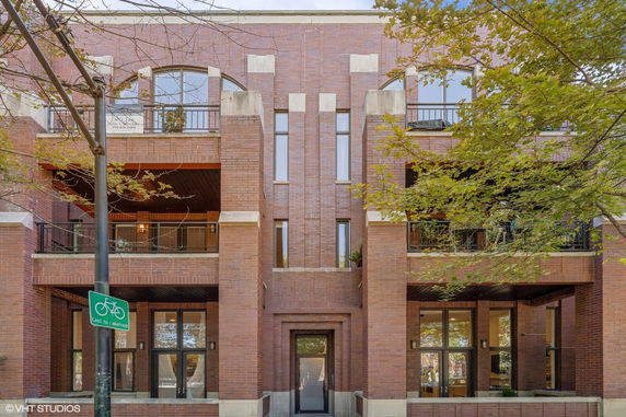 Front view of a multi-story brick building with balconies.