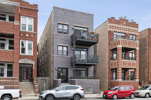 Front view of a multi-story apartment building with balconies.