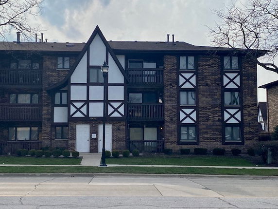 Front view of a three-story apartment building with a Tudor-style façade.