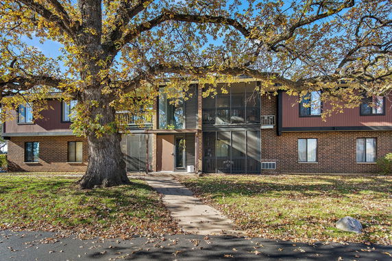 Front view of a two-story brick building with large windows and a central entryway.