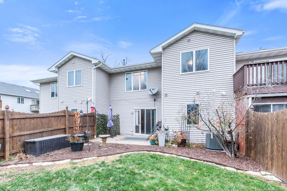 Rear view of a two-story house with fenced backyard.