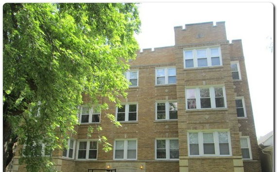 Front view of a multi-story brick building with multiple windows.